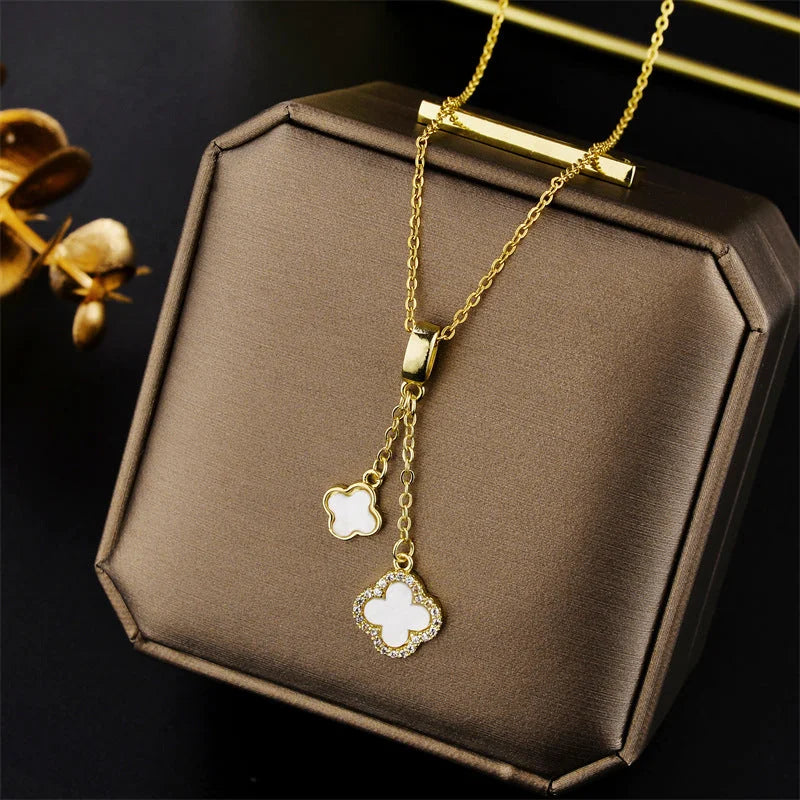 Gold necklace with floral pendants on a brown jewelry box
