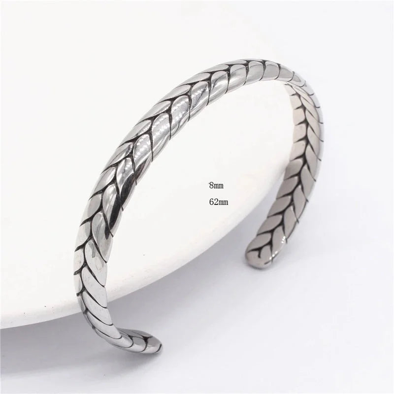 Silver bangle with leaf-like pattern on a white background