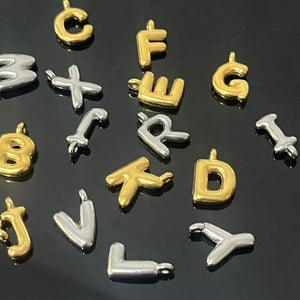 Gold and silver letter charms on a black background