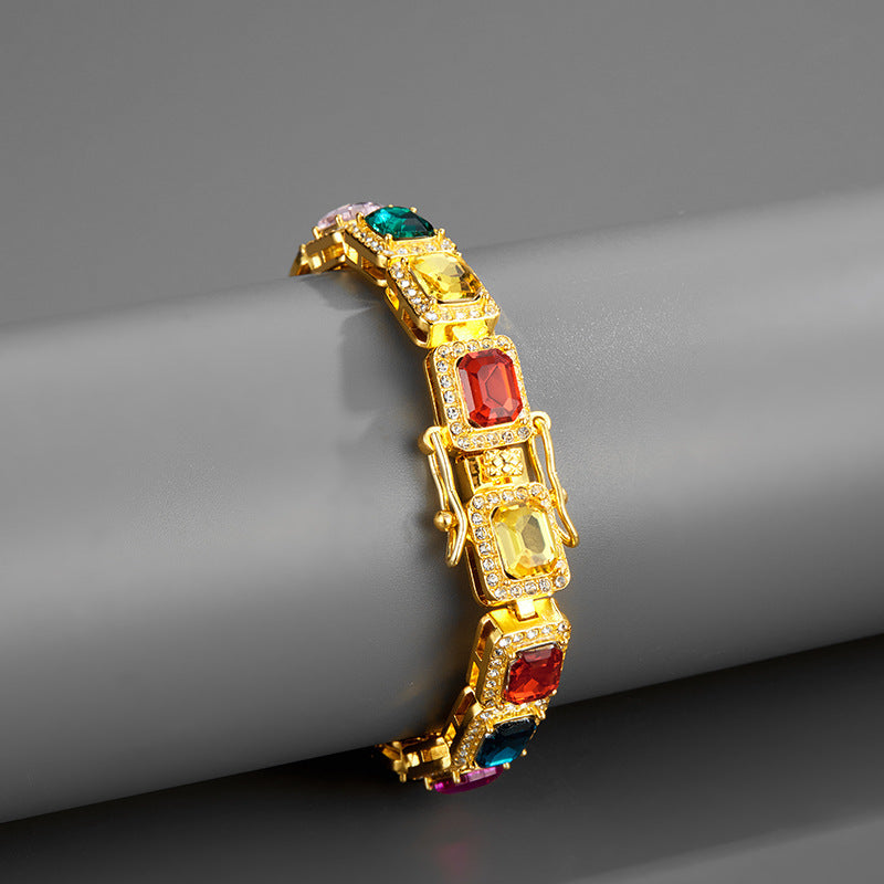 Gold bracelet with colorful gemstones on a gray surface