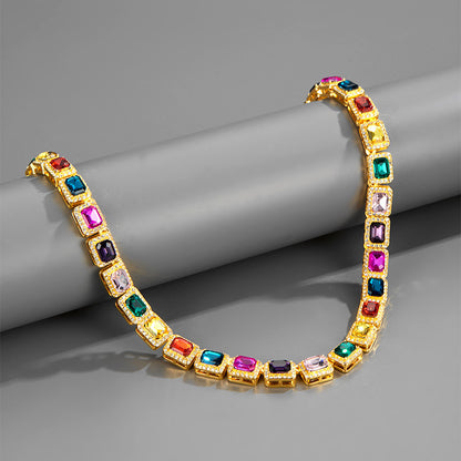 Gold bracelet with colorful gemstones on a gray surface