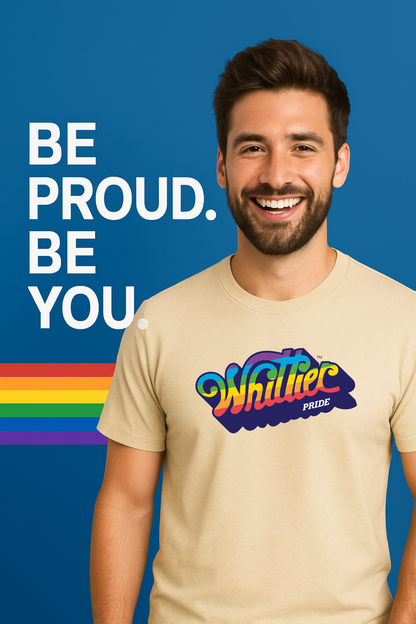 Man wearing a beige t-shirt with 'Whittle' Pride logo on a blue background with text 'Be Proud. Be You'.