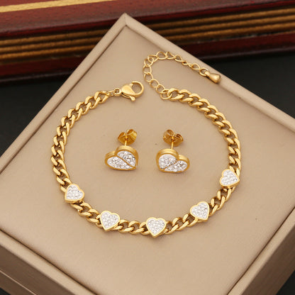 Gold bracelet and heart-shaped earrings on a beige jewelry box