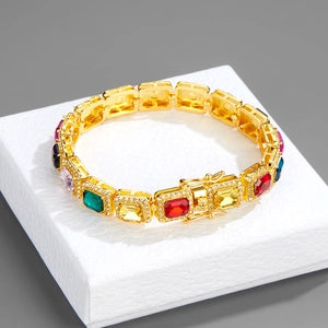 Gold bracelet with colorful gemstones on a white box