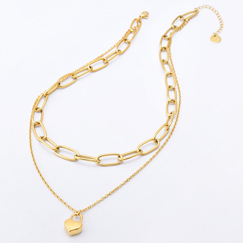 Gold chain necklace with a heart pendant on a white background