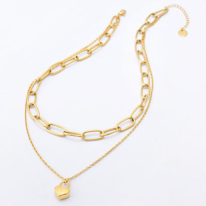 Gold chain necklace with a heart pendant on a white background