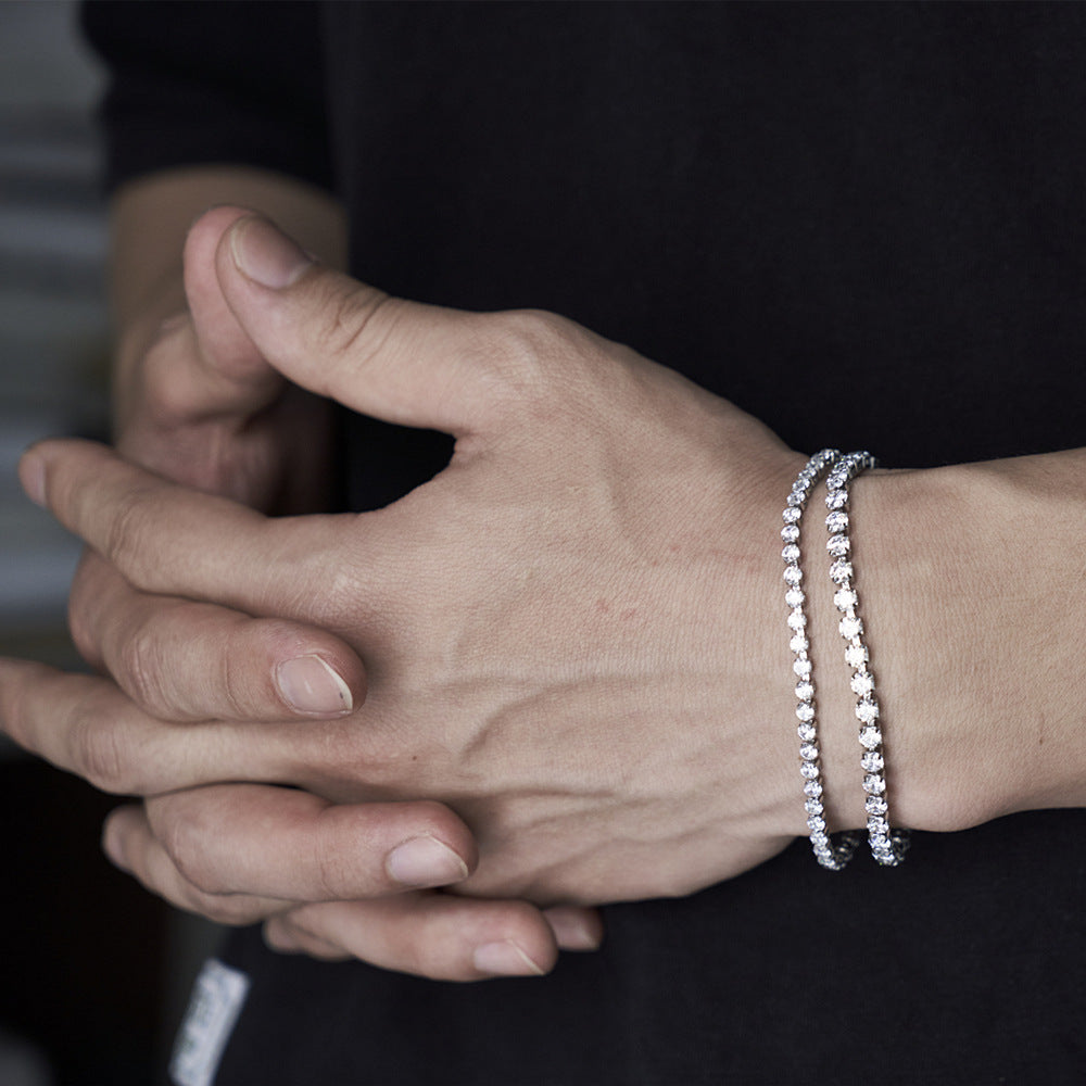 Close-up of hands with silver beaded bracelets on a blurred background