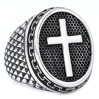 Silver ring with a textured band and central cross design on a white background