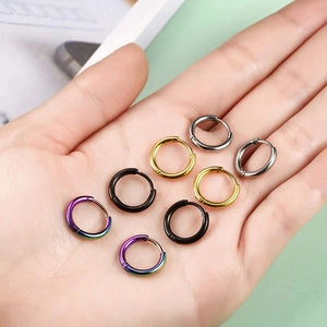 Colorful metal rings on a hand with a light green background