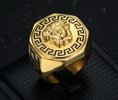 Gold ring with intricate design on a black textured background
