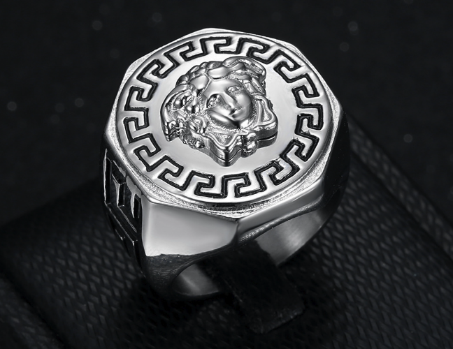 Silver ring with intricate design on a dark textured background