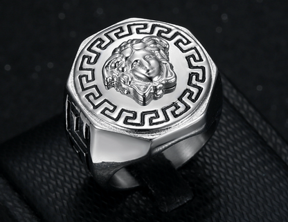Silver ring with intricate design on a dark textured background
