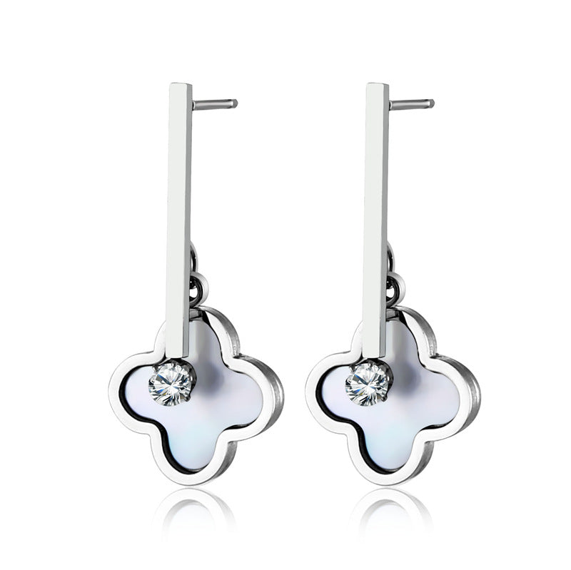 Silver earrings with clover-shaped designs on a white background