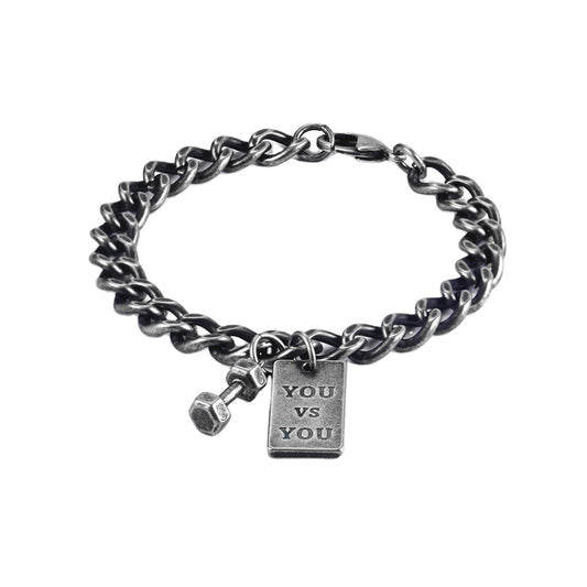 Silver chain bracelet with a 'YOU VS YOU' tag on a white background