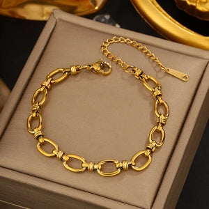 Gold bracelet on a gray box with a blurred background