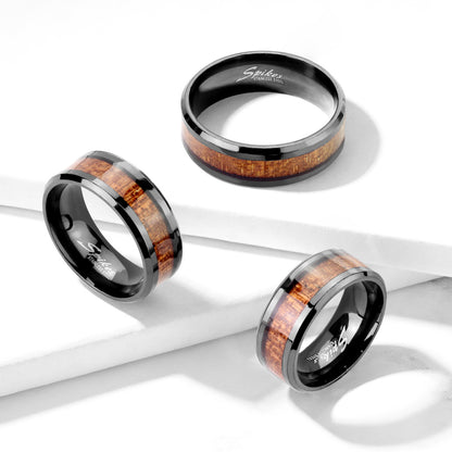 Two black IP stainless steel rings with wood inlay center, one displayed on a white surface and the other on a human hand showing the fit and design.
