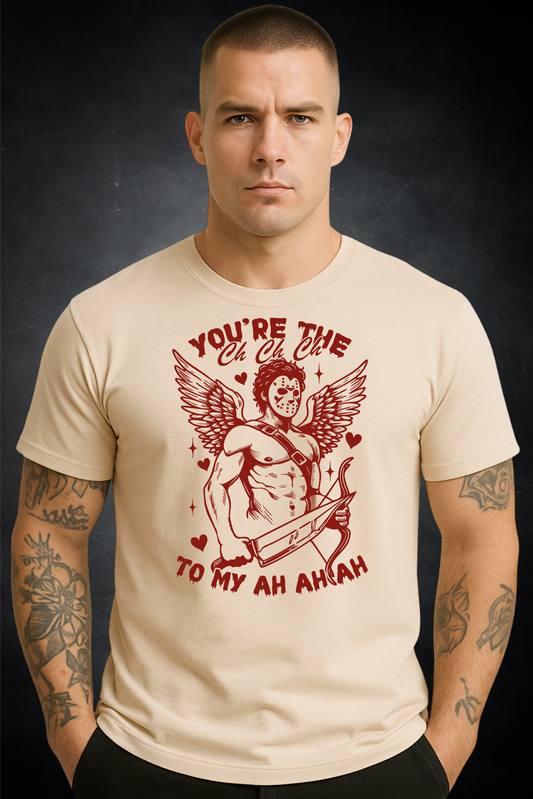 Man wearing a beige t-shirt with a graphic design and text on a dark background