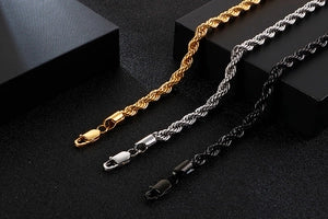 Three gold, silver, and black chain necklaces on a dark background
